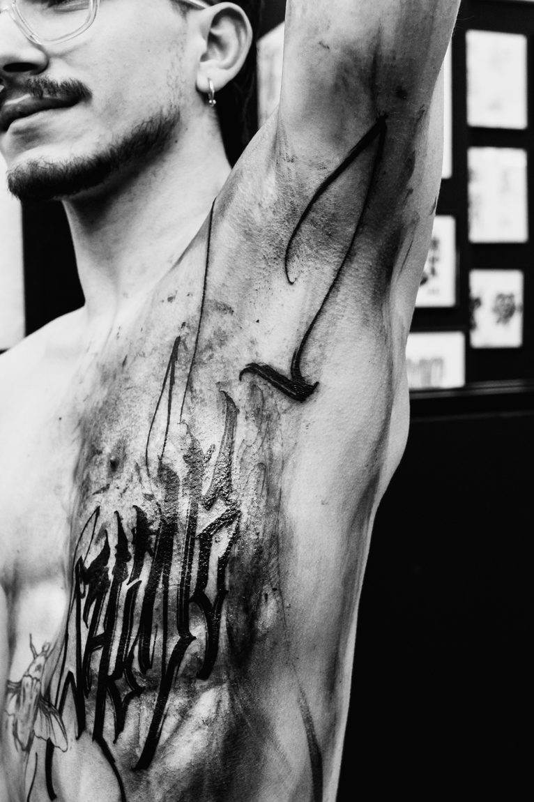 Il fianco appena tatuato, il braccio alzato. Bodymarkings, Bologna.