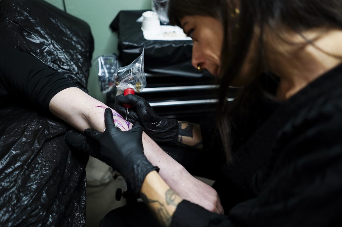 L'ago sul braccio, il guanto nero. Ora Berlin Tattoo, Berlino.