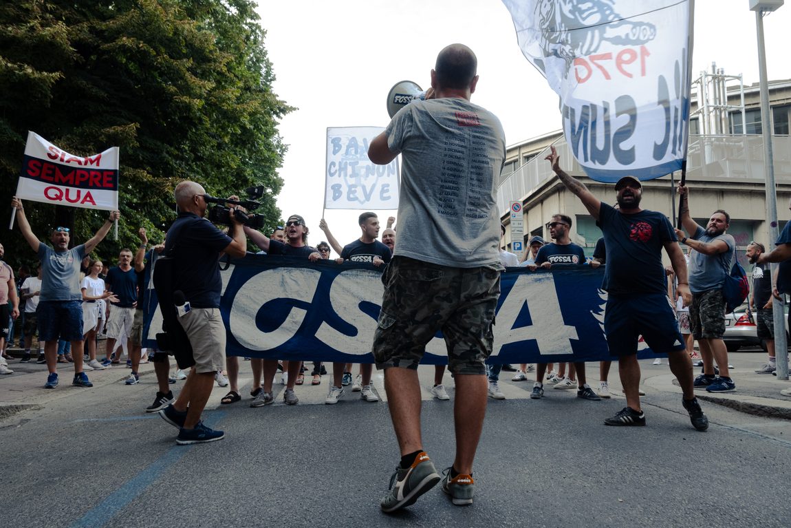 Dietro lo striscione, per strada sotto la pioggia. FAITH · Fossa dei Leoni, Bologna.