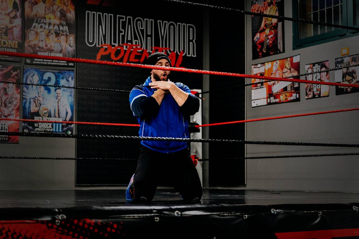 In ginocchio sul ring, sotto la scritta in palestra. Red Scorpion — Fabio Giarratano.